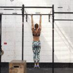 Fit woman dead hanging from a bar in the gym