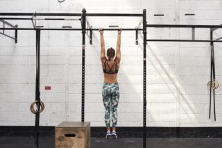 Fit woman dead hanging from a bar in the gym
